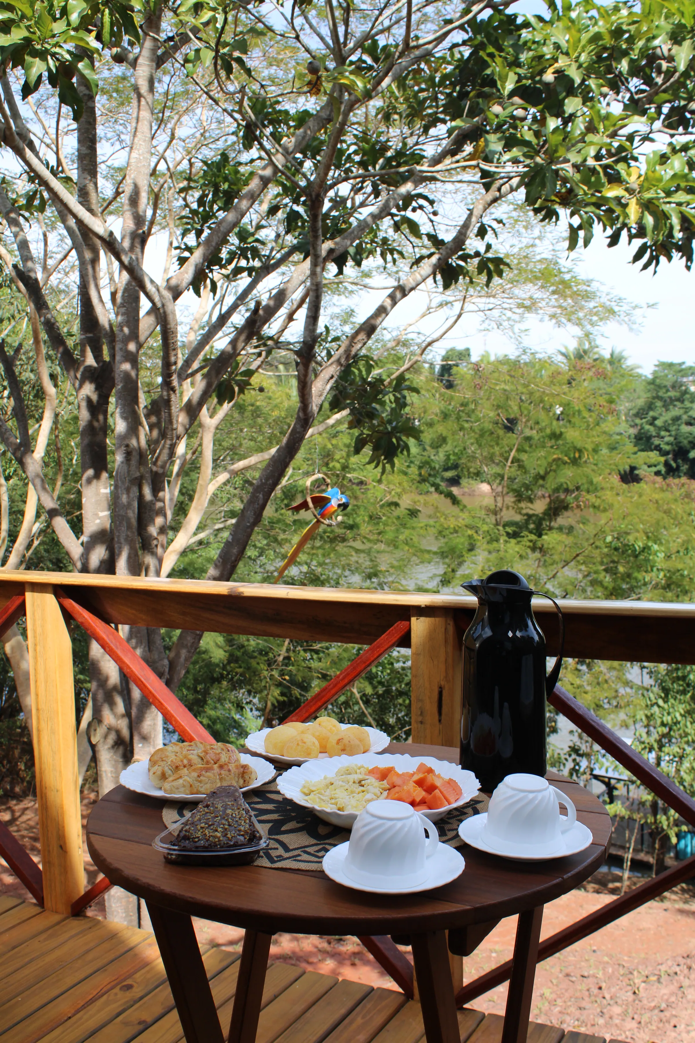 Café da manhã servido no deck entre as árvores