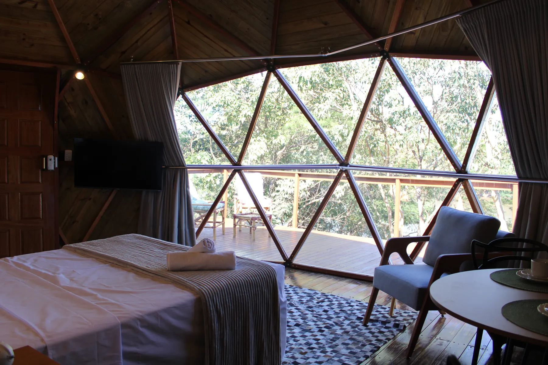 Cama de casal do Domo Aurora virada para a janela geodésica