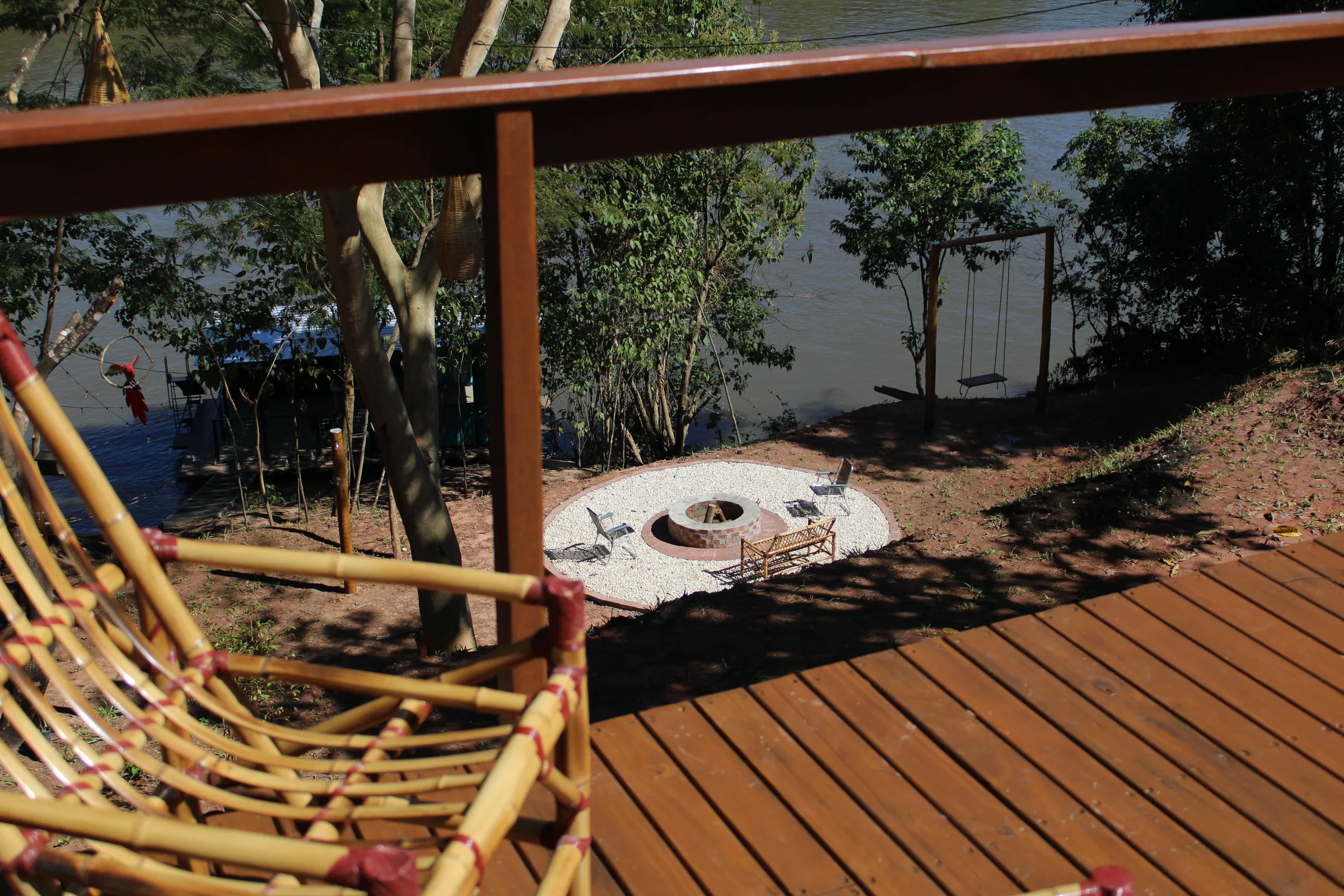 Vista do deck para a fogueira à beira do rio
